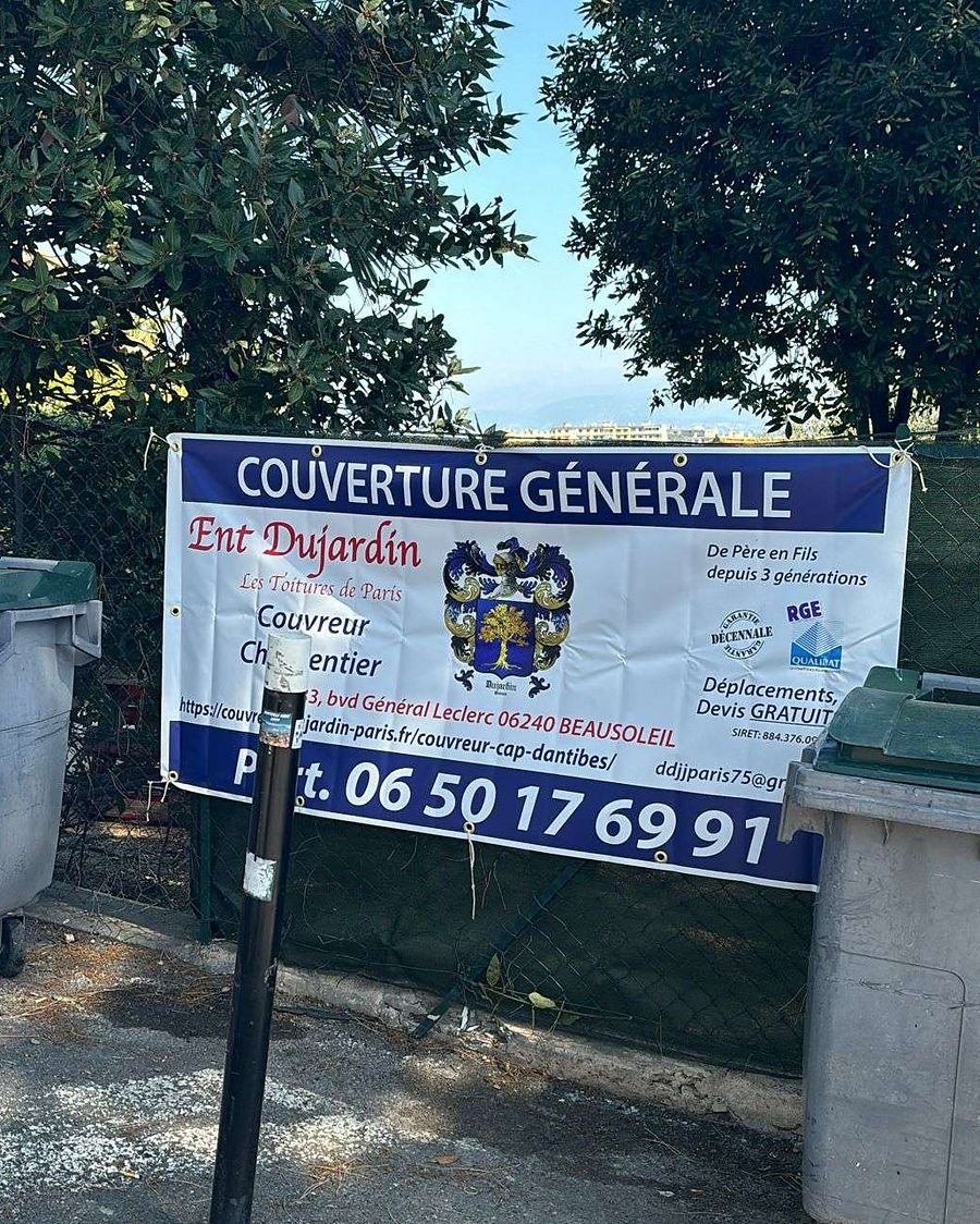 Panneau de chantier Dujardin Couverture, avec le numéro 06 50 17 69 91, sur un chantier des Alpes-Maritimes