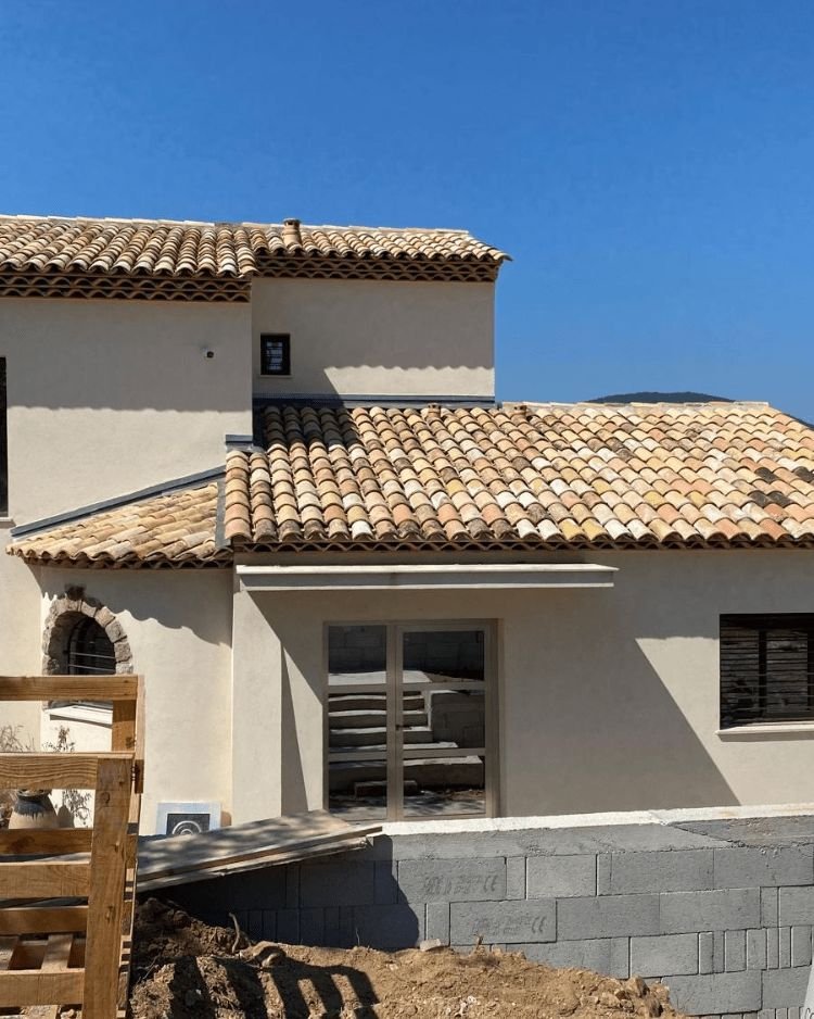 Villa aux toitures neuves en tuiles de terre cuite, sous le ciel bleu de la Côte d'Azur