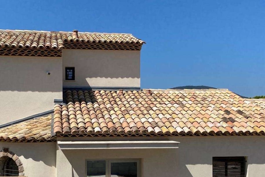 Détail d'une toiture de villa en tuiles de terre cuite, rives et faîtage soignés